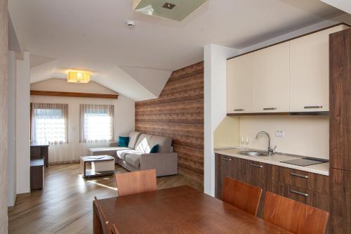 a kitchen and living room with a table and a couch at Central Inn in Zlatibor