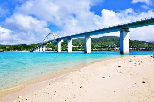 a bridge over the beach next to a beach at オーシャンテラス瀬底303 in Ufugumui