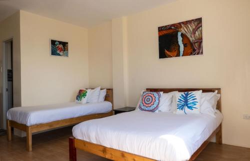 2 camas en una habitación con paredes blancas en Masayahin Cabanavillas, en Santander