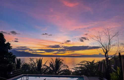a sunset over a body of water with a swimming pool at Masayahin Cabanavillas in Santander