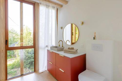 ein Badezimmer mit einem roten Waschbecken und einem Spiegel in der Unterkunft Moulin du Buis - Bain nordique, charme et détente in Saint-Sorlin-en-Bugey