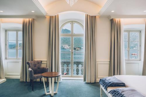 a bedroom with a bed and a table and a chair at Heritage Grand Perast By Rixos in Perast