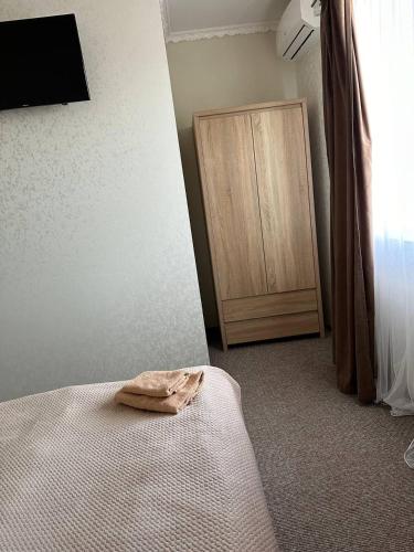 a bedroom with a bed and a wooden cabinet at Готель-спа "Еліт" in Kolʼchyno