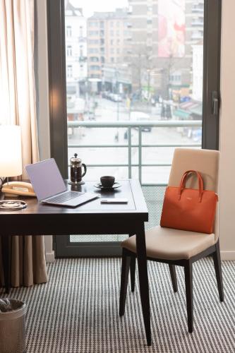 a laptop computer sitting on a desk in front of a window at Sofitel Brussels Europe in Brussels