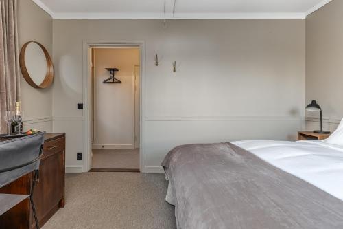 1 dormitorio con cama, tocador y espejo en Brunnsvik Hotell & Konferens en Ludvika