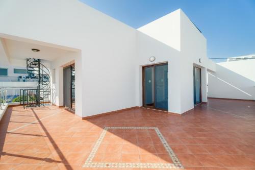 a room with a tile floor and a white building at Seafront Protaras Villas in Protaras