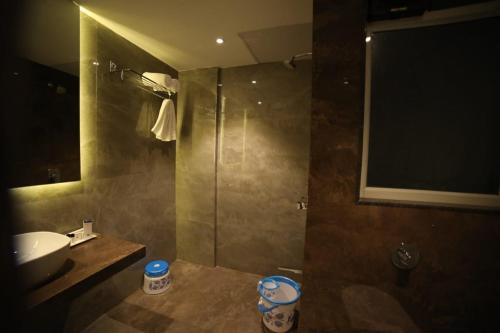 a bathroom with a toilet and a sink and a shower at Hotel Midland, Nanded in Nānded