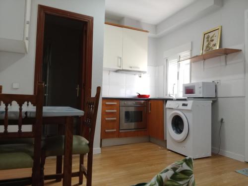 uma cozinha com uma mesa e uma máquina de lavar roupa em Home P.C em Getafe