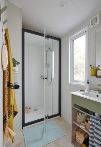 une salle de bain avec douche et lavabo dans l'établissement Camping maeva Respire La Comtesse, à Bélus