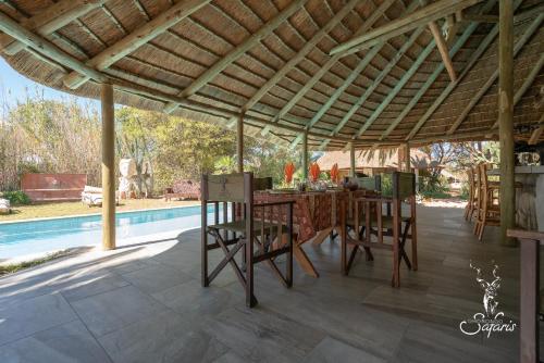 un patio con tavolo, sedie e piscina di Ohorongo Safari Lodge a Kamanjab