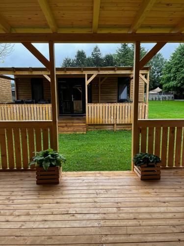 a wooden deck with two potted plants on it at Mobilna hiška Hupi in Velenje