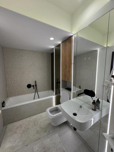 y baño con lavabo, aseo y bañera. en Apartament de lux, en Bucarest