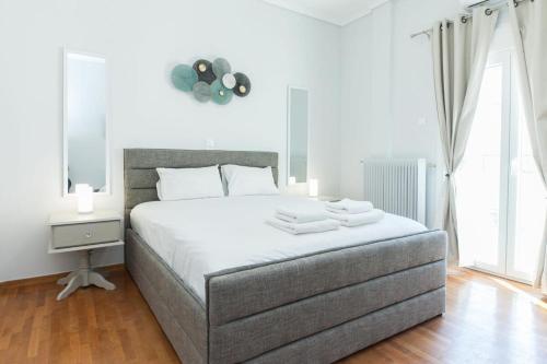 a white bedroom with a large bed and a mirror at Shades of Athens in Athens