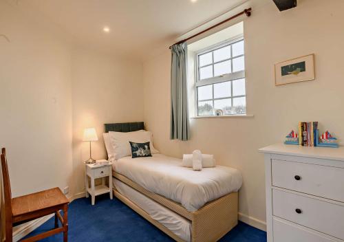 a small bedroom with a bed and a window at Orchard Retreat in Docking