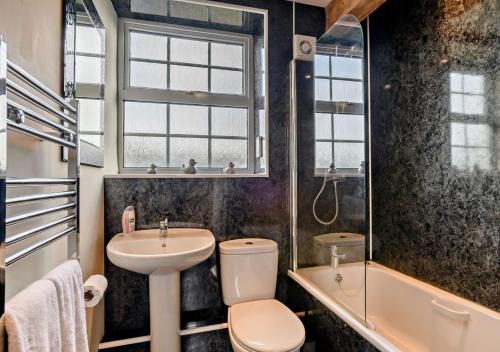 a bathroom with a toilet and a sink and a shower at Orchard Retreat in Docking
