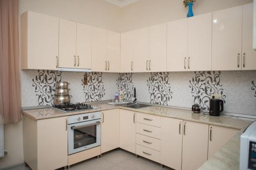 a kitchen with white cabinets and a stove at Chakvi Lux House in Chakvi
