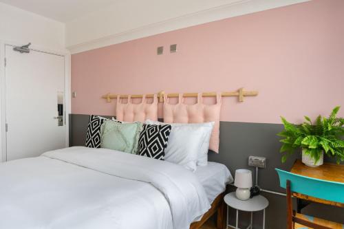 a bedroom with two beds and a pink wall at PH Hostel Liverpool in Liverpool