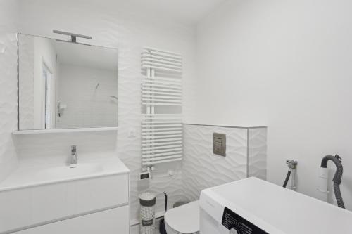 a bathroom with a sink and a toilet and a mirror at Chic et minimaliste studio Batignolle/Montmartre by Weekome in Paris