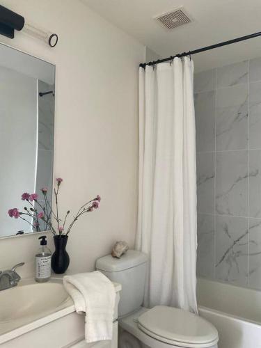 a white bathroom with a toilet and a sink and a tub at North Beach Retreat in Atlantic City