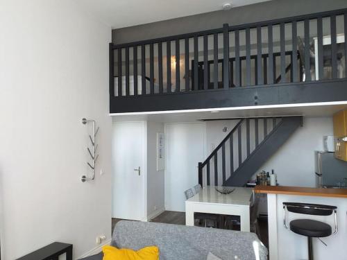 Habitación con escalera y cocina con mesa. en Cap Lihou, en Granville