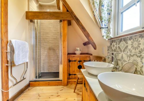 uma casa de banho com 2 lavatórios e uma janela em Orchard Cottage em East Dereham