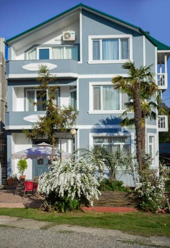 a white building with trees and flowers in front of it at Chakvi Lux House in Chakvi