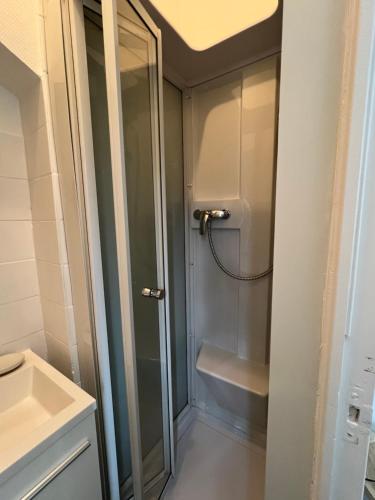 une douche dans une salle de bain avec une porte vitrée dans l'établissement V 1 - Confortable studio près gare et centre-ville, à Rennes