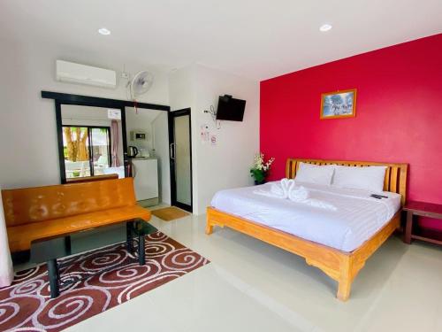 Un dormitorio con una cama y una pared roja. en Fisherman Resort at Sam Roi Yot, en Baanphakrimlay 