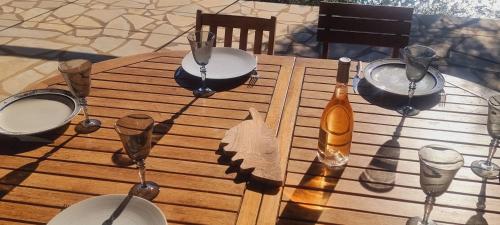 une table en bois avec des assiettes et des verres à vin dessus dans l'établissement Villa à Fautea, 8 pers, piscine chauffée, pieds dans l'eau, à Conca