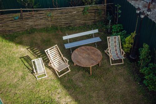 a table and four chairs and a wooden bench at Chakvi Lux House in Chakvi