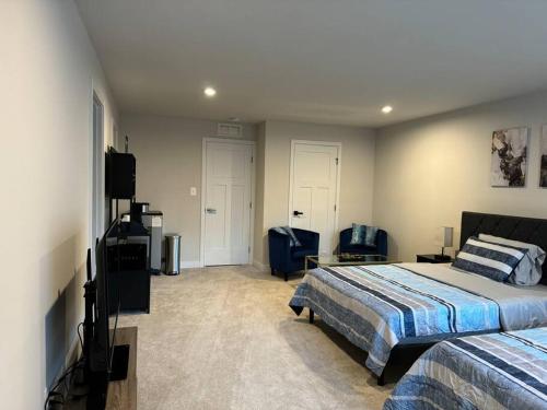 Cozy room in Charlottesville في Earlysville: غرفة نوم بسريرين وتلفزيون بشاشة مسطحة