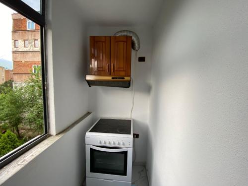 a kitchen with a stove and a window at Apartament me qera 2+1 in Kukës