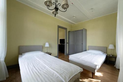 a bedroom with two beds and a chandelier at Tiigi Apartment in Paide