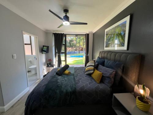 - une chambre avec un lit et un ventilateur de plafond dans l'établissement Afrique134 Willow Tree Private Garden Suite, à Pretoria