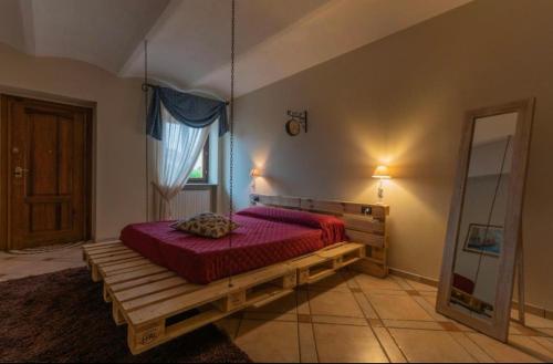 una camera con un letto con copriletto rosso di certe notti langhe a Salmore