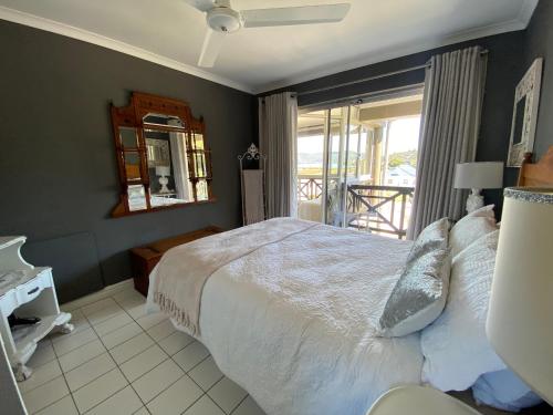 a bedroom with a large bed and a balcony at 10 Summerplace in Knysna