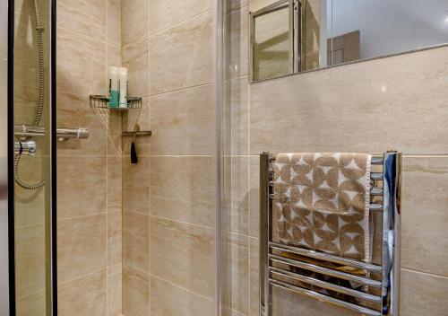 a shower with a glass door and a towel at Pelican Eco Lodge in East Carleton