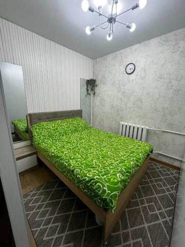 a bedroom with a large bed with a green comforter at Centrala in Bălţi