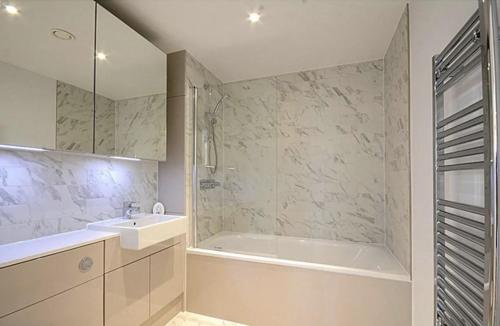 a bathroom with a tub and a sink and a shower at Luxury Collection - London Bridge in London