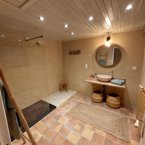 une salle de bain avec un lavabo et un miroir dans l'établissement La Rapiette, à Payroux