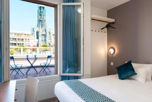 a bedroom with a bed and a view of the eiffel tower at The Originals City, Hôtel Notre Dame, Rouen in Rouen