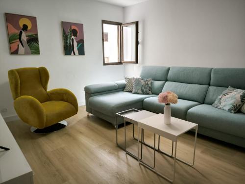 a living room with a blue couch and a chair at El Álamo Las Nieves Agaete & Parking in Puerto de las Nieves
