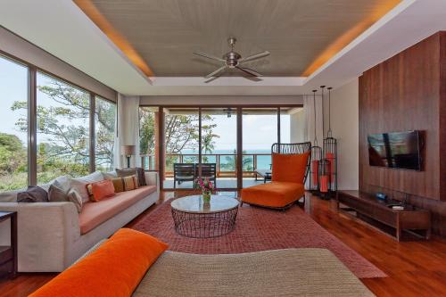a living room with a couch and a tv at ShaSa Resort & Residences, Koh Samui - SHA Extra Plus in Lamai