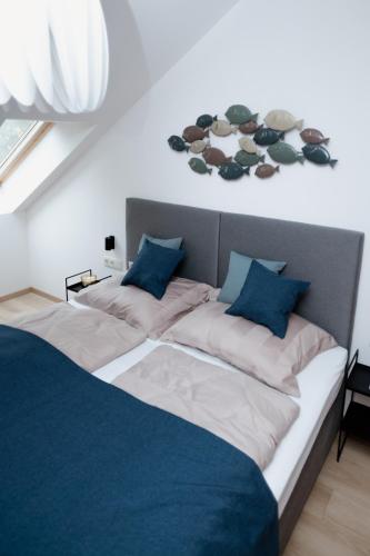 a bedroom with two beds with blue pillows at Zafír Home in Keszthely