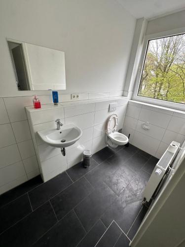 La salle de bains est pourvue d'un lavabo et de toilettes. dans l'établissement Domum 9 Moderne Ferien- Monteurapartments inkl Wlan und Waschmaschine, à Marl