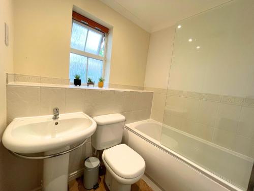 W łazience znajduje się umywalka, toaleta i wanna. w obiekcie A Lovely Home Stay Near Greenwich w Londynie