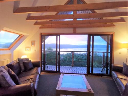 a living room with a couch and a large window at ArdFyne on Lochfyne in Strachur