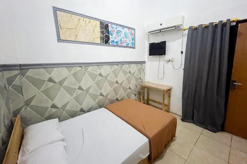 een kleine slaapkamer met een bed en een raam bij Forzando House Redpartner near Universitas Muhammadiyah Malang in Malang