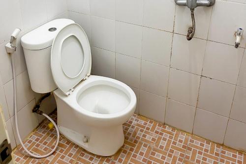 een badkamer met een wit toilet in een stal bij Forzando House Redpartner near Universitas Muhammadiyah Malang in Malang