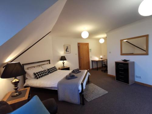 a bedroom with a bed and a table and a mirror at ArdFyne on Lochfyne in Strachur